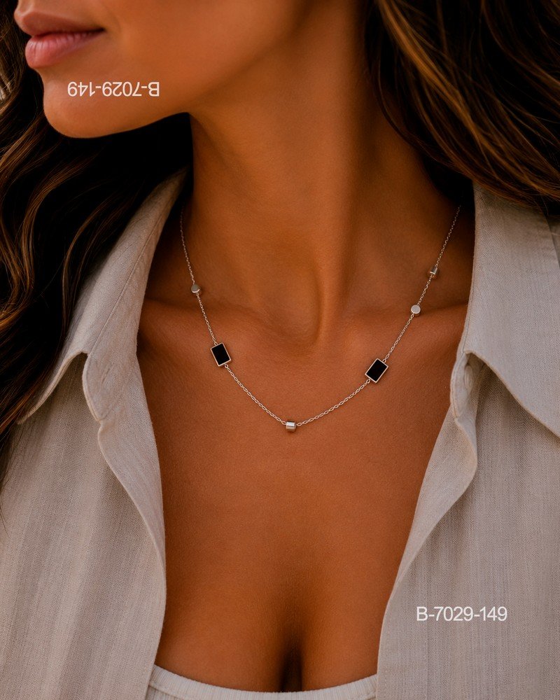 Collar o gargantilla de diseño delicado en color plateado o metalizado, compuesto por una cadena fina con pequeños detalles tubulares y esféricos, y dijes rectangulares B7029