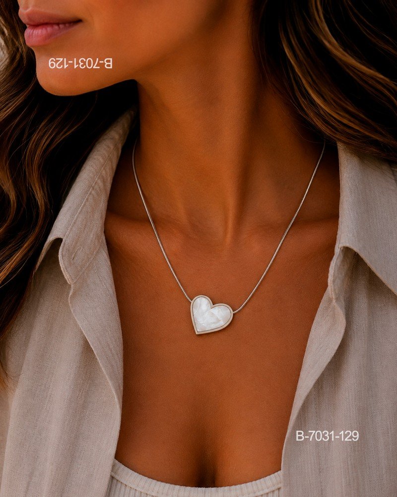 Collar o gargantilla de diseño delicado en color plateado o metalizado, compuesto por una cadena fina tipo serpiente y un dije colgante en forma de corazón B7031