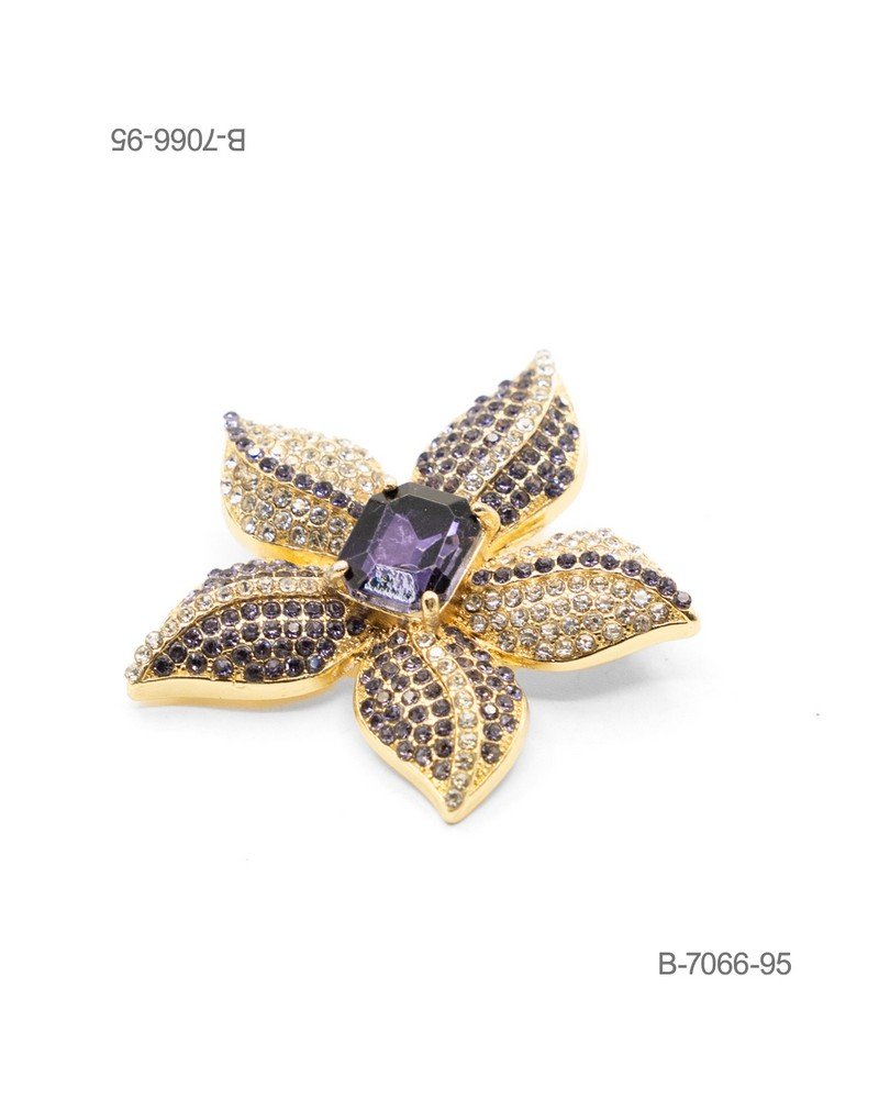Prendedor de diseño elegante en color dorado, con forma de flor pavimentada de pedrería brillante en tonos claros y oscuros, coronada por un gran cristal central de corte rectangular en color violeta B7066