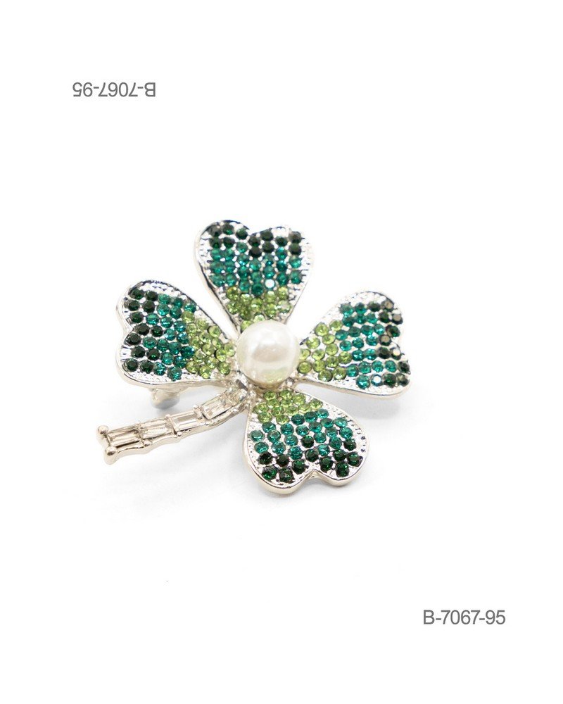 Prendedor de diseño elegante en color plateado, con forma de trébol de cuatro hojas ornamentado con pedrería brillante en degradé de tonos verdes y oscuros, un tallo con incrustaciones y una perla central B7067