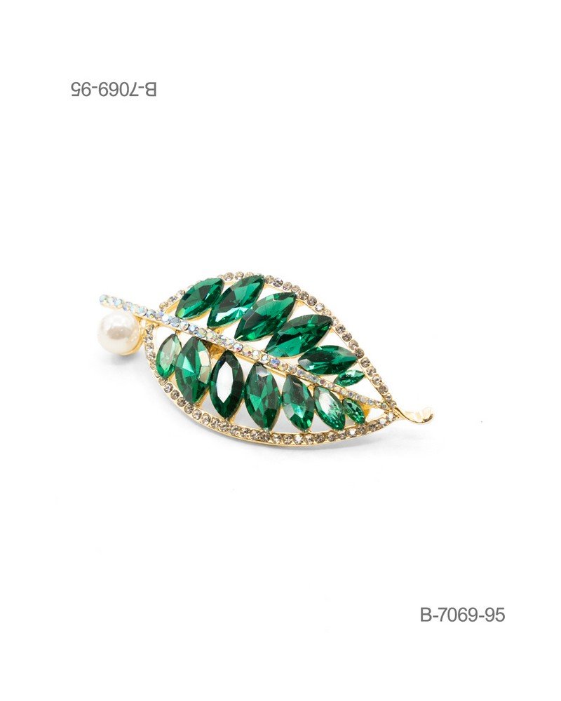 Prendedor de diseño elegante en color dorado, con forma de hoja ornamentada con grandes cristales facetados de color verde esmeralda, bordes de pedrería brillante y una perla decorativa en el tallo B7069