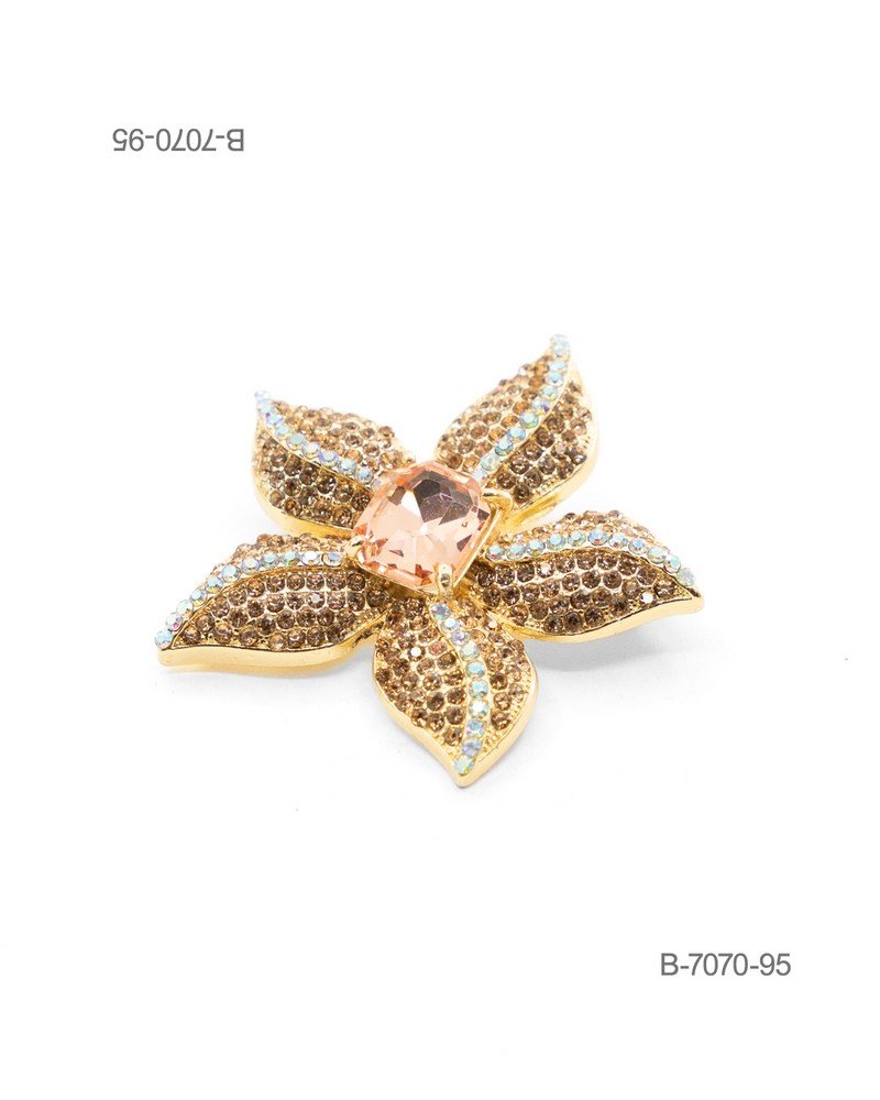 Prendedor de diseño elegante en color dorado, con forma de flor pavimentada de pedrería brillante en tonos marrones y detalles tornasolados, coronada por un gran cristal central de corte rectangular en tono rosado B7070