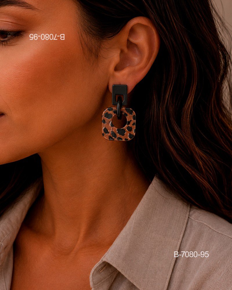 Aros o pendientes colgantes de diseño moderno, compuestos por un pequeño aplique superior rectangular de color negro y una pieza colgante cuadrada con estampado animal print B7080